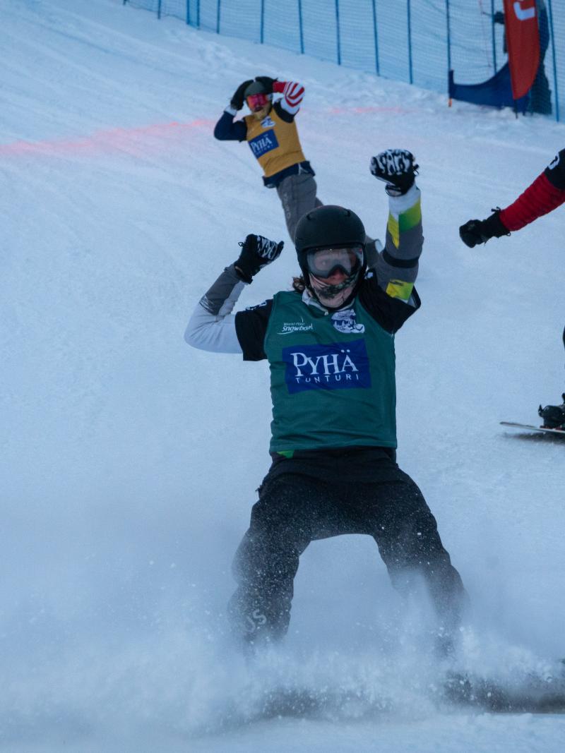 Male snowboarder celebrates after crossing finishline