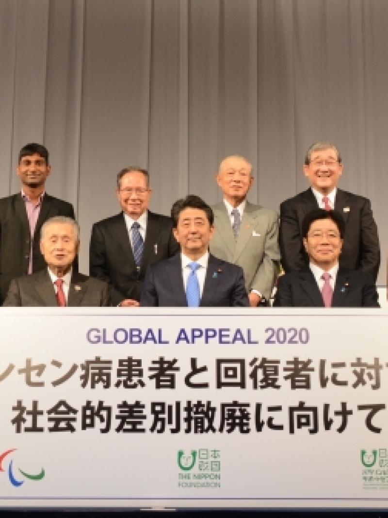 Group photo of Japanese people around a big banner