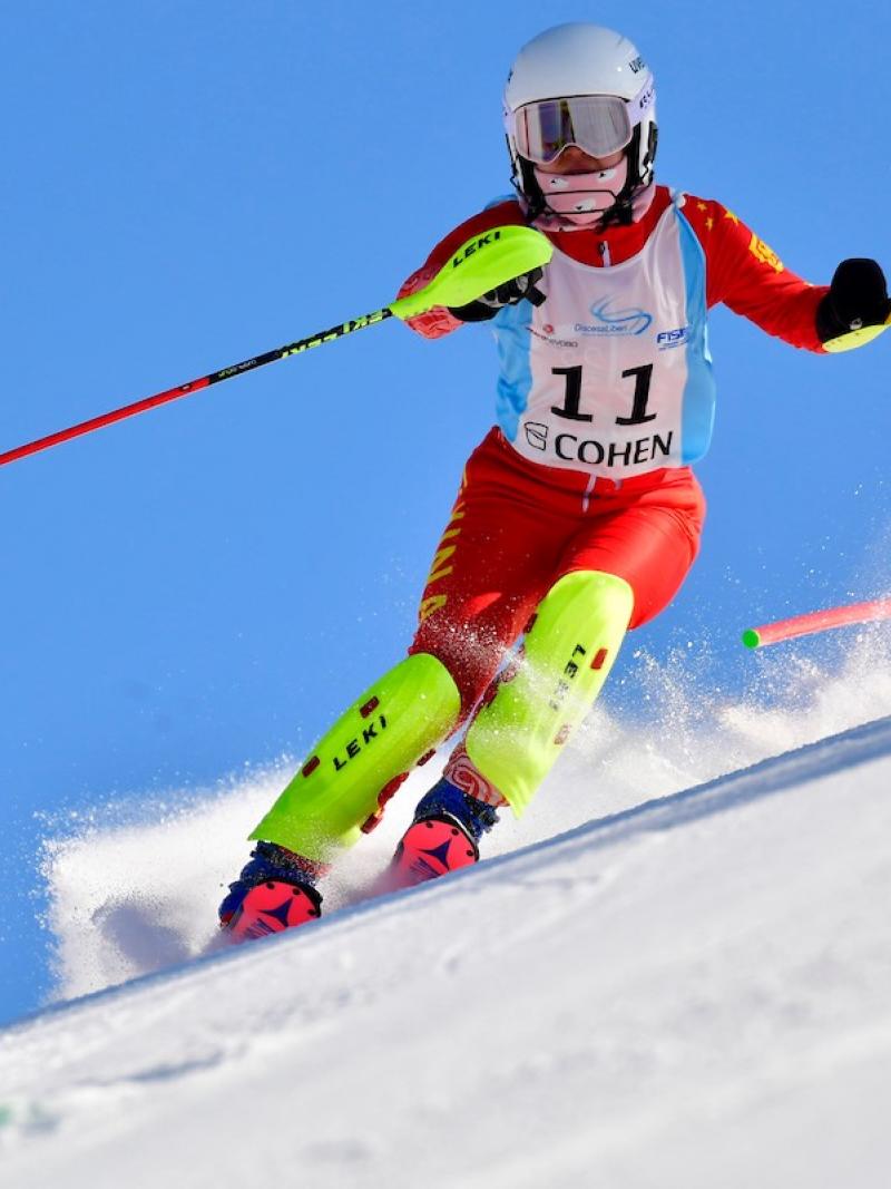 Chinese standing skier comes down the mountain