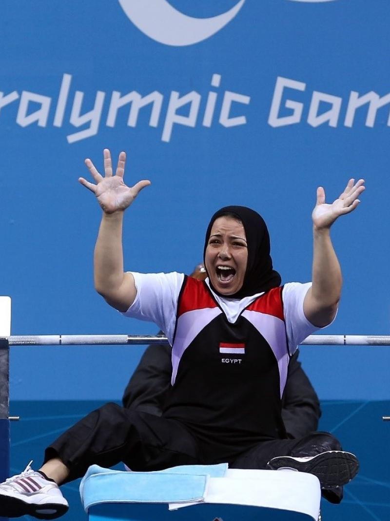A female powerlifter celebrating being watched by man