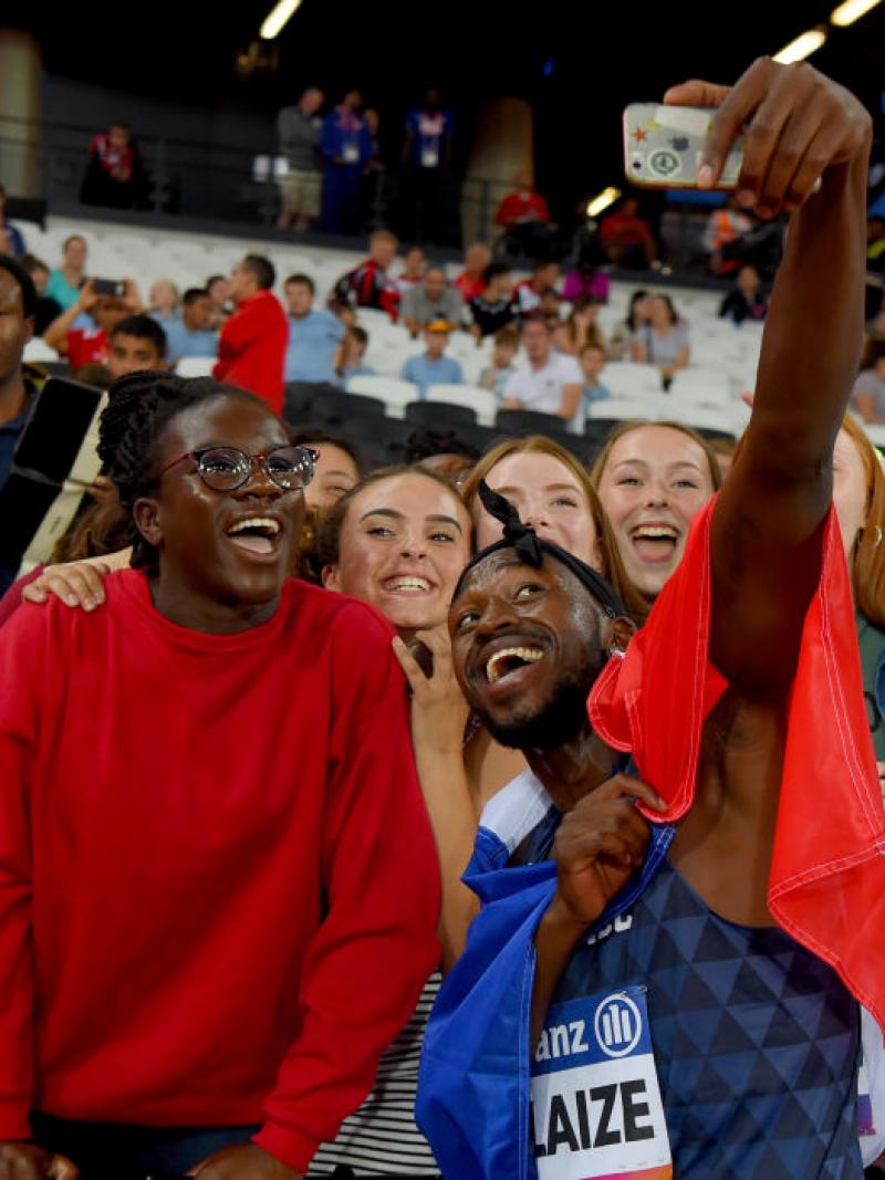 French Black man takes selfie with fans and French flag around him