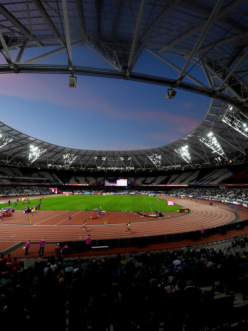 A general view of the London Stadium showing the stands, the athletics track with athletes competing