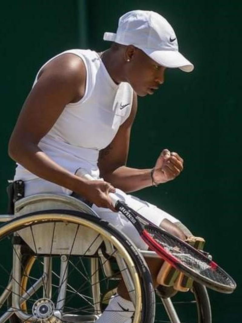 Black female wheelchair tennis player celebrates a point