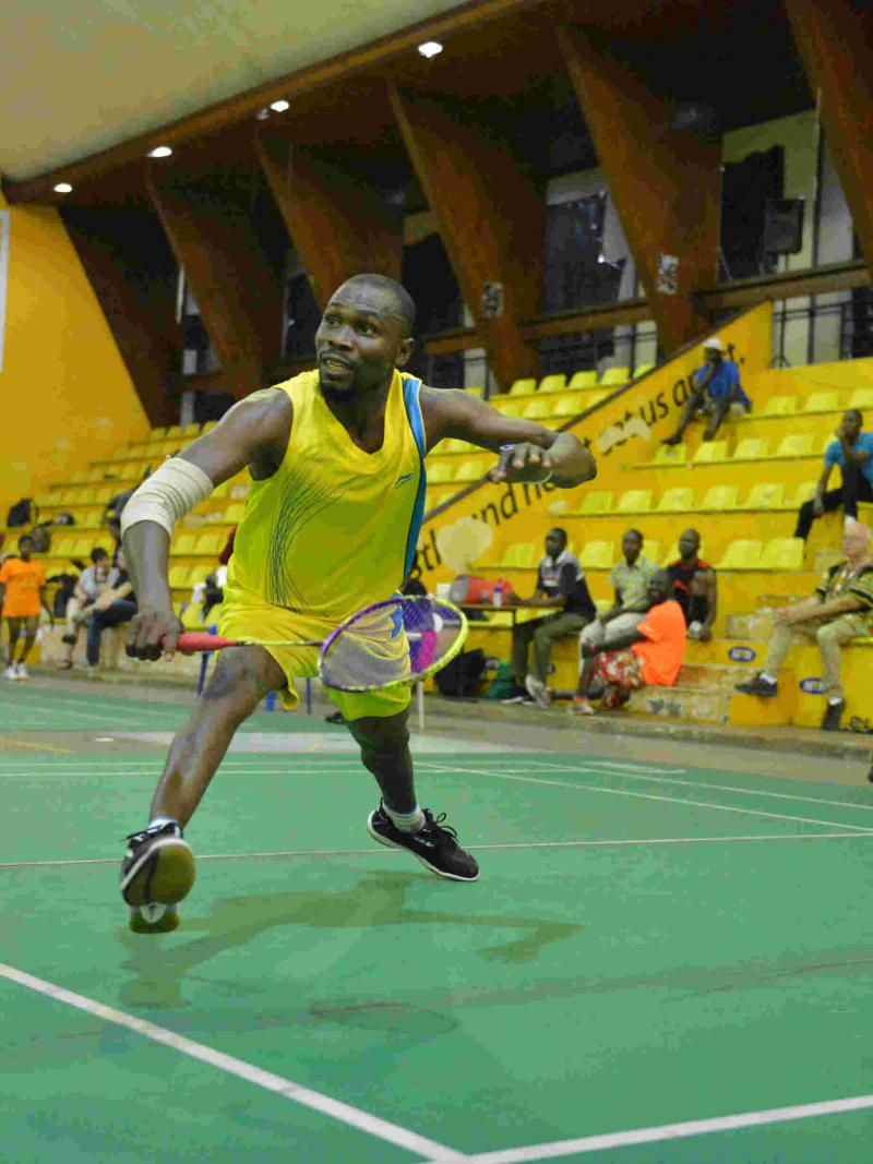 Nigerian man reaches to return the shuttle in badminton