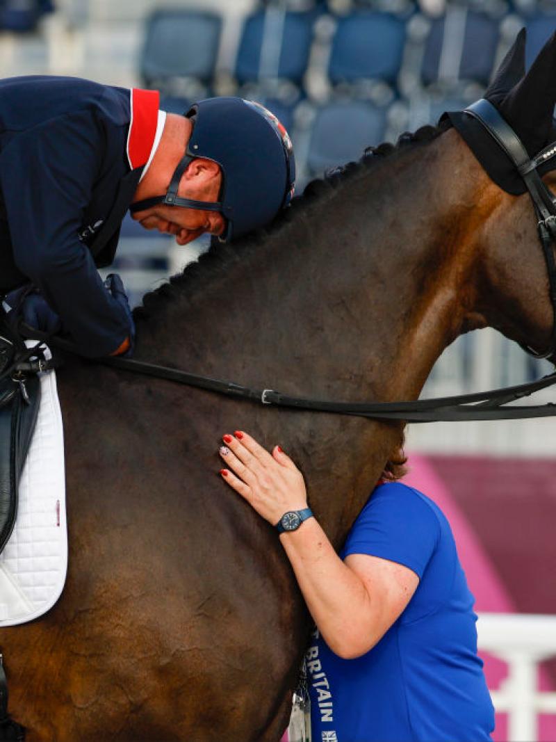 Lee Pearson lays his head on his horse