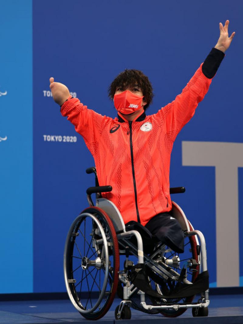 A man in a wheelchair with the uniform of Japan on a podium at the Tokyo 2020 Paralympic Games