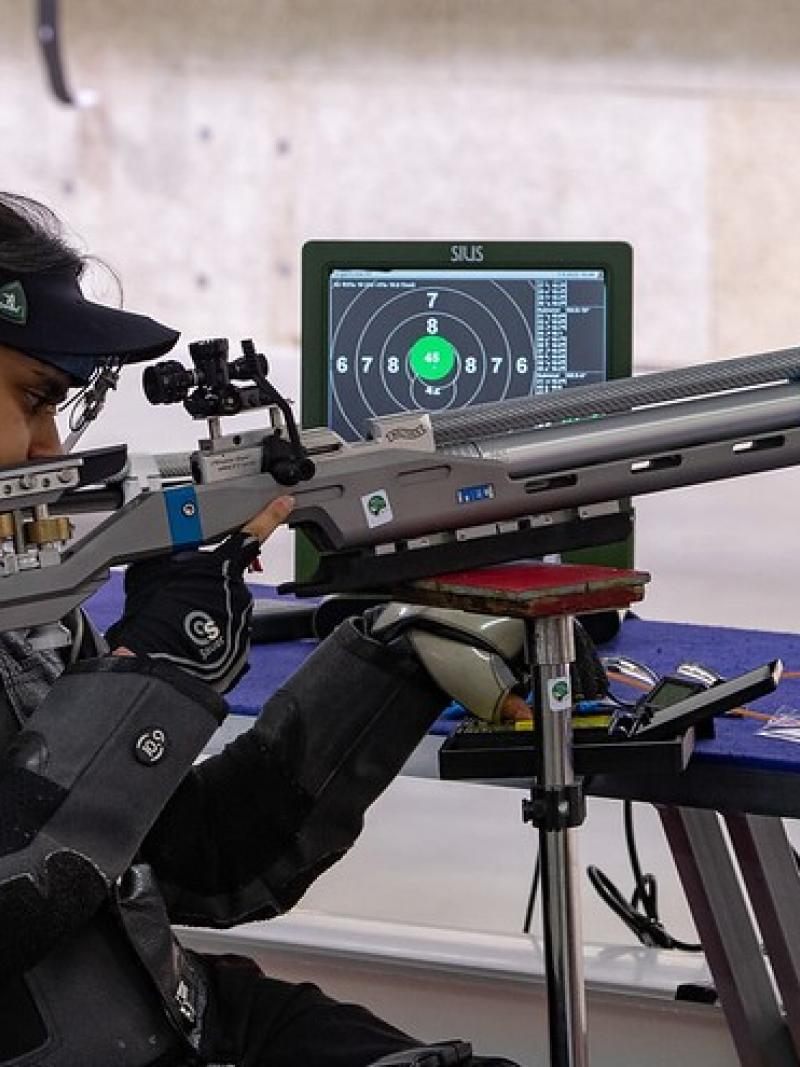 A female shooter with a rifle in a shooting Para sport competition