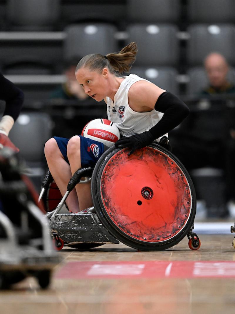 A female wheelchair rugby athlete plays with male players.