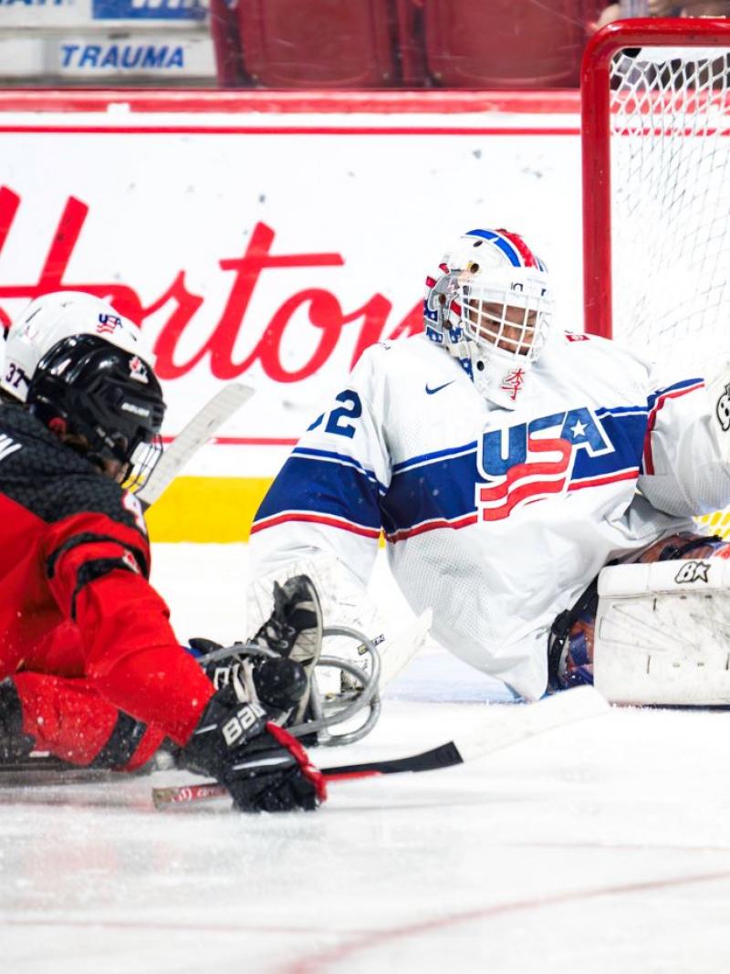 A hockey goaltender making a save from an opponent's shot