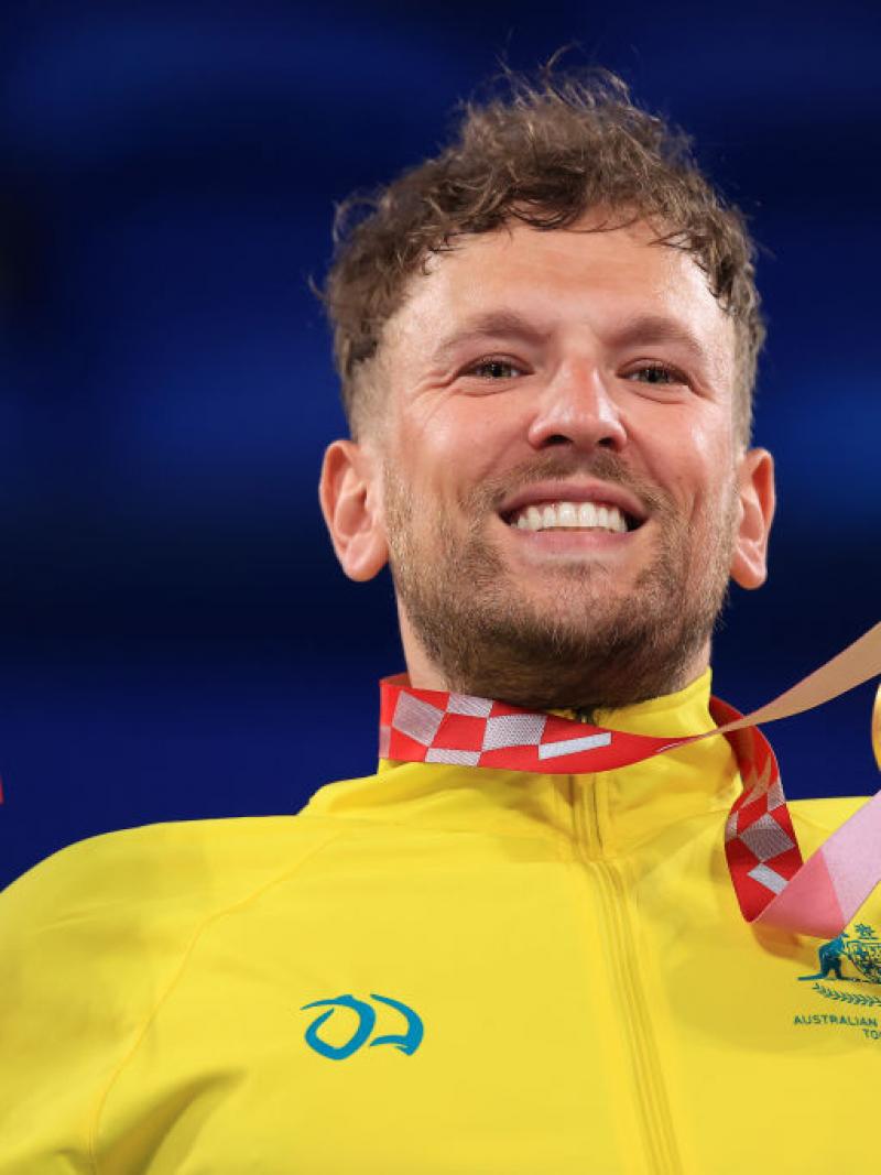 Dylan Alcott, a male wheelchair tennis player, poses for a photo with a gold medal.