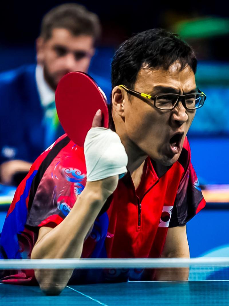 A male Para table tennis player prepares to return the ball.