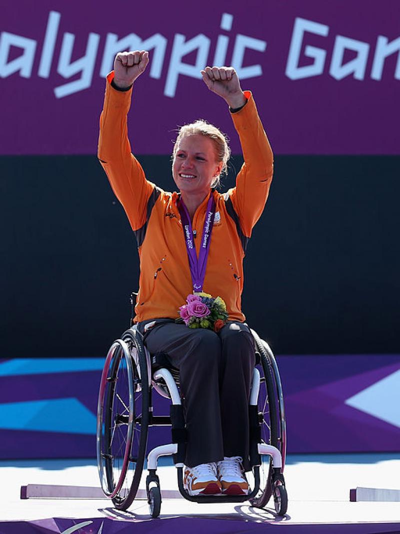 Esther Vergeer raises both hands to celebrate after receiving her gold medal.