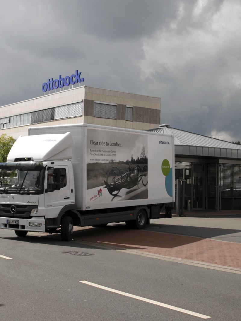 A picture of two trucks leaving a firm