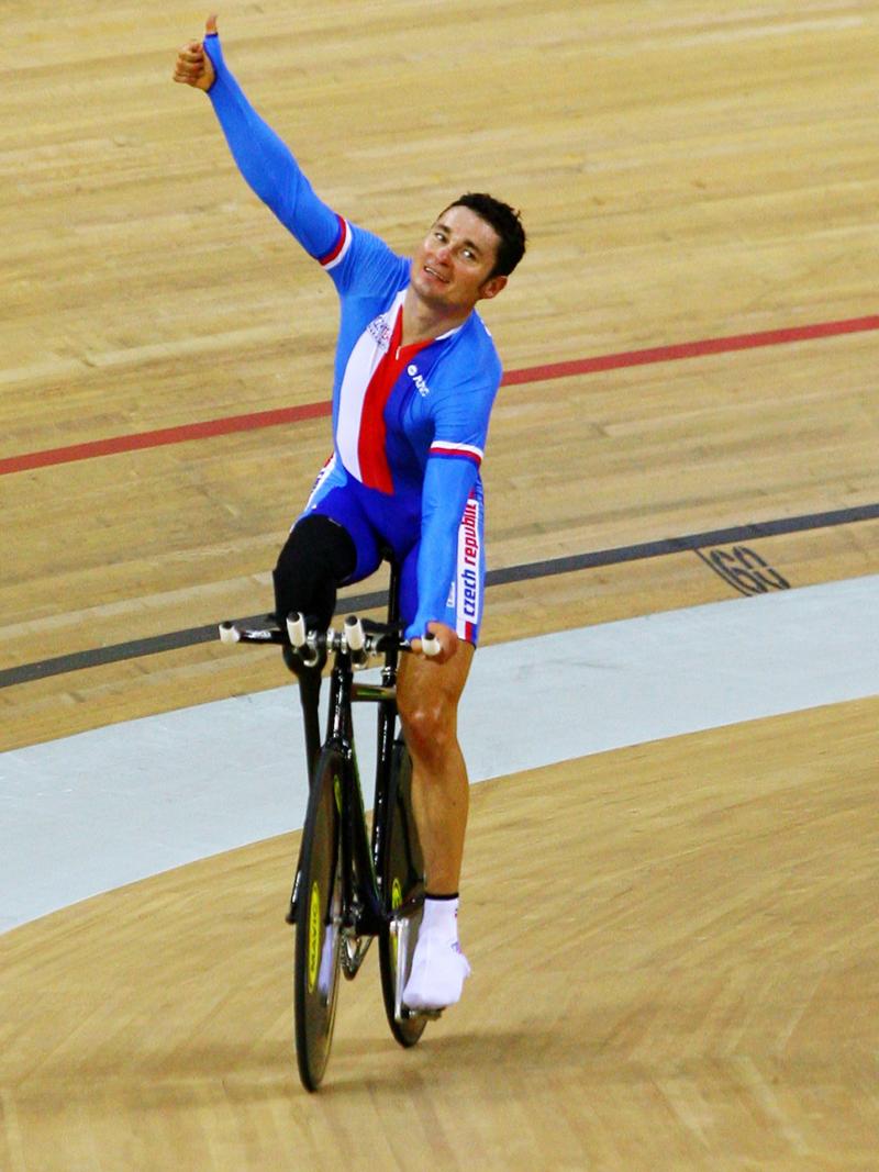 A picture of a man celebrating his victory on a bike