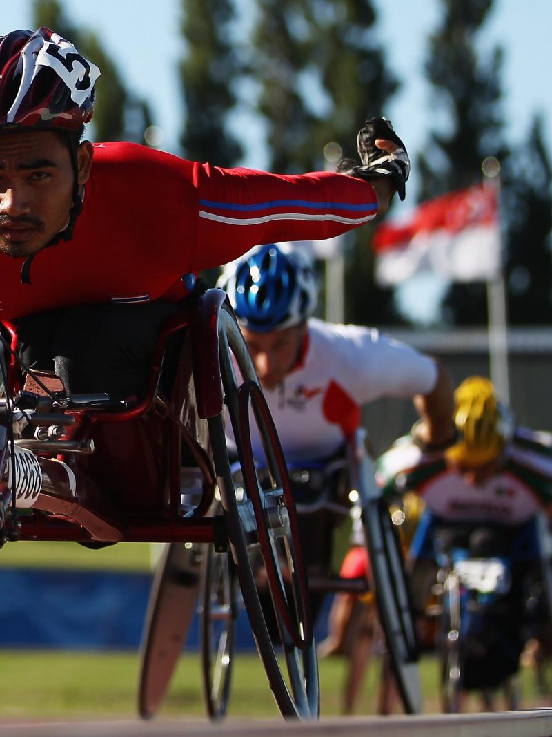 A picture of a man in a wheelchair racing on a track