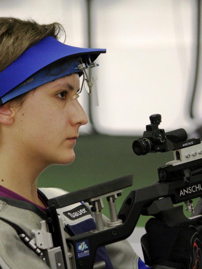 Athlete holding a rifle while practicing shooting.