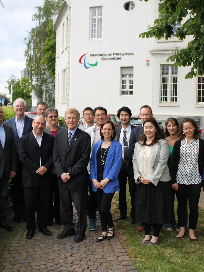 A group of people pose for a photo in front of the IPC headquarters building.