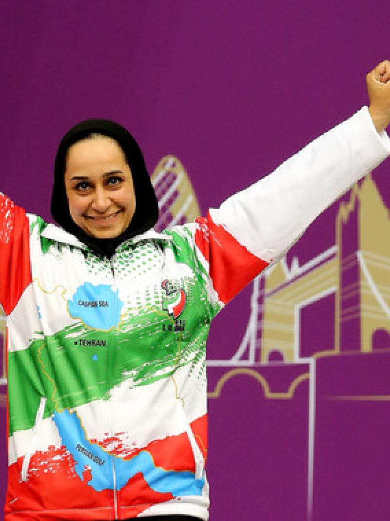 A woman raises her arms in celebration.