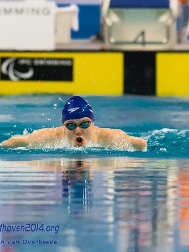 A swimmers emerges from the water to begin a stroke