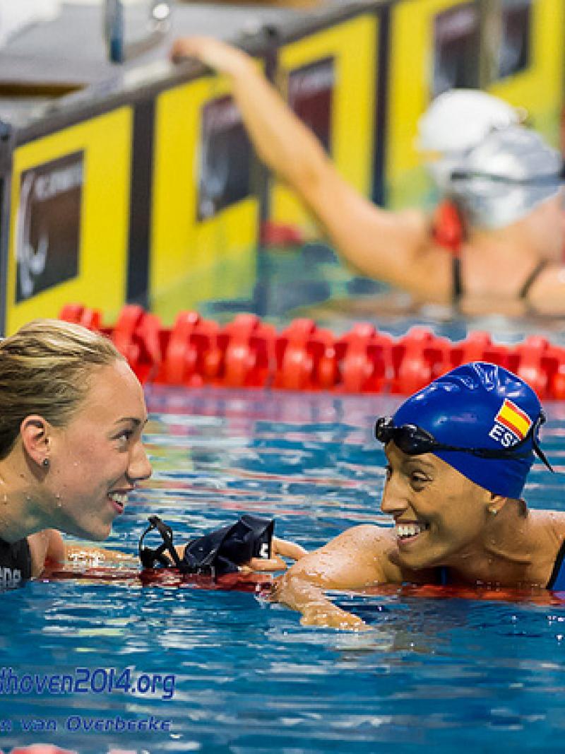 Two swimmers smile at each other after competing at the 2014 IPC Swimming European Championships