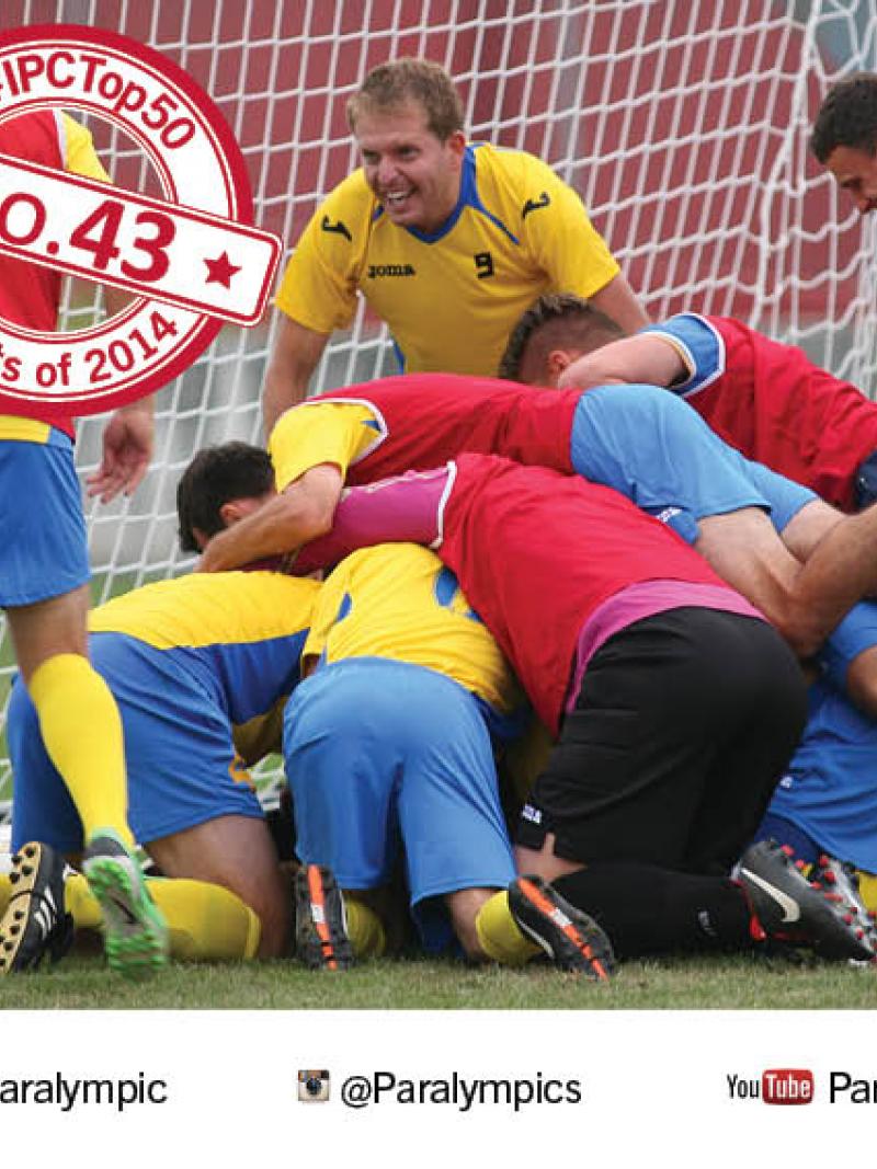 Players celebrate, jumping one on another on a football field of play