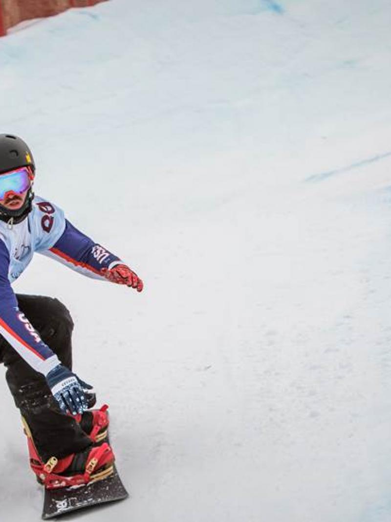 Two snowboarders race on a slope