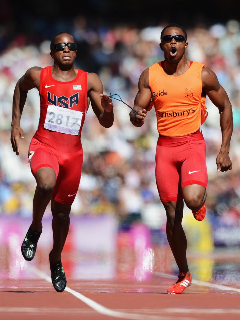 Runner and guide run in a full stadium