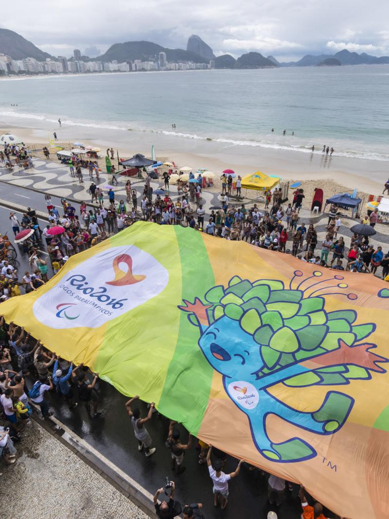 Crowd of people from above, holding a huge banner with Rio motives