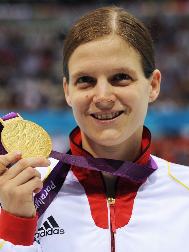 Portrait shot of woman showing a medal and smiling