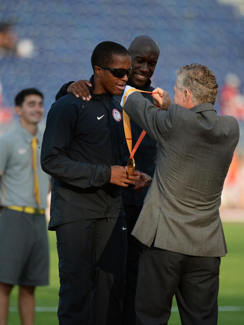 Two men on the podium receiving a medal