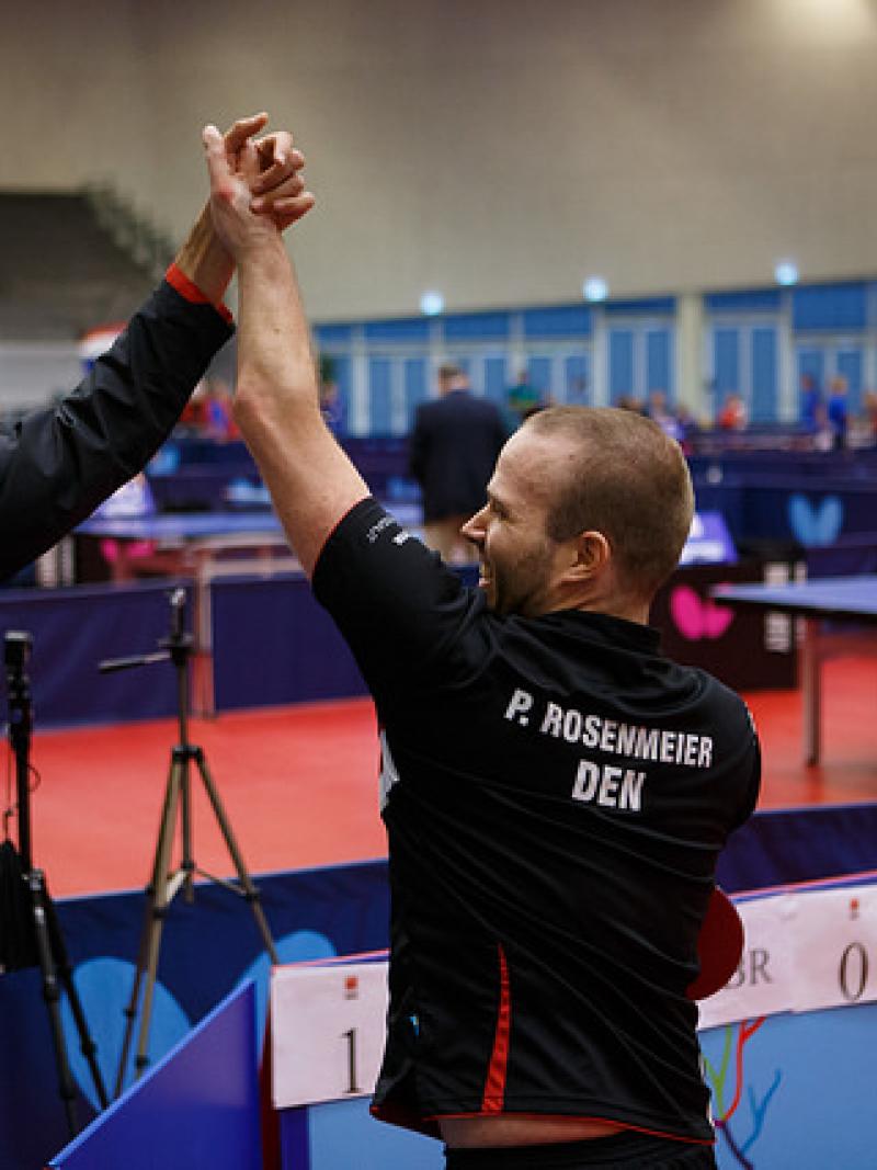 Two table tennis players celebrate.