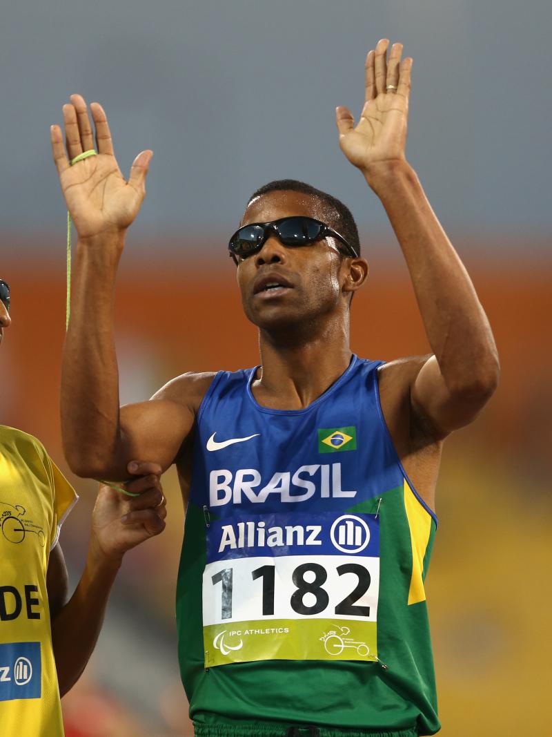 Blindfolded man and guide celebrate after crossing the finish line