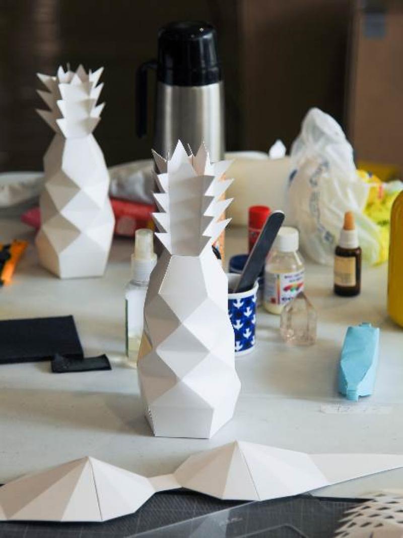 On a table, pineapples and bras made out of paper.
