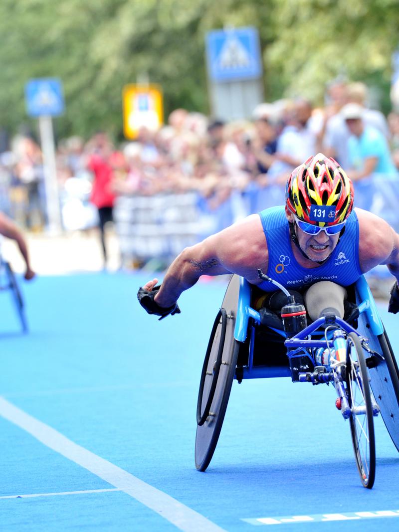 Man in racing wheelchair outside on a street