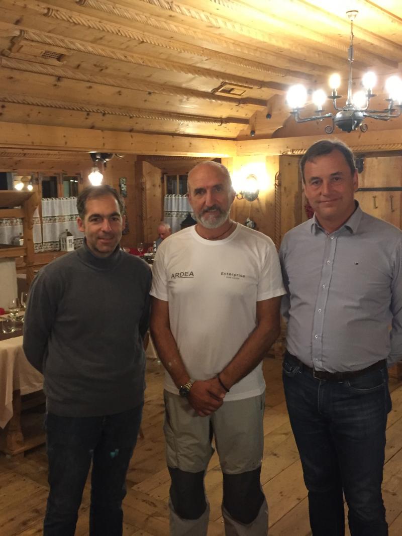 Three men stand in a group