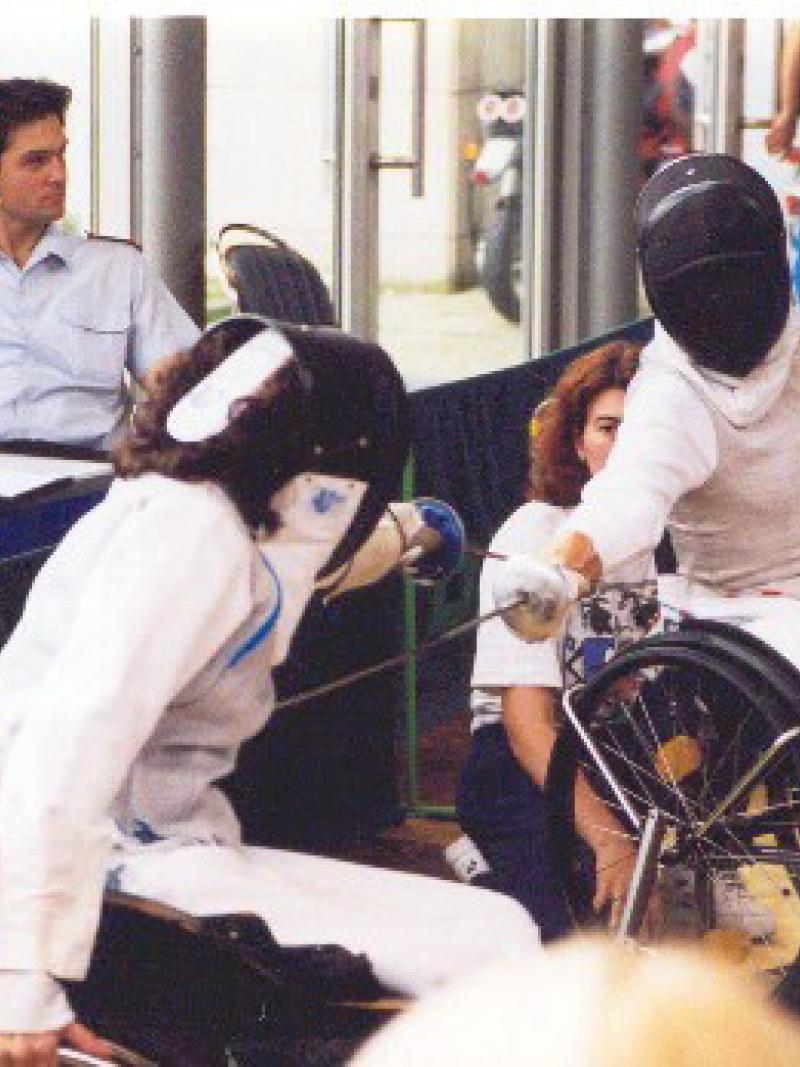 Two people in wheelchairs, fencing