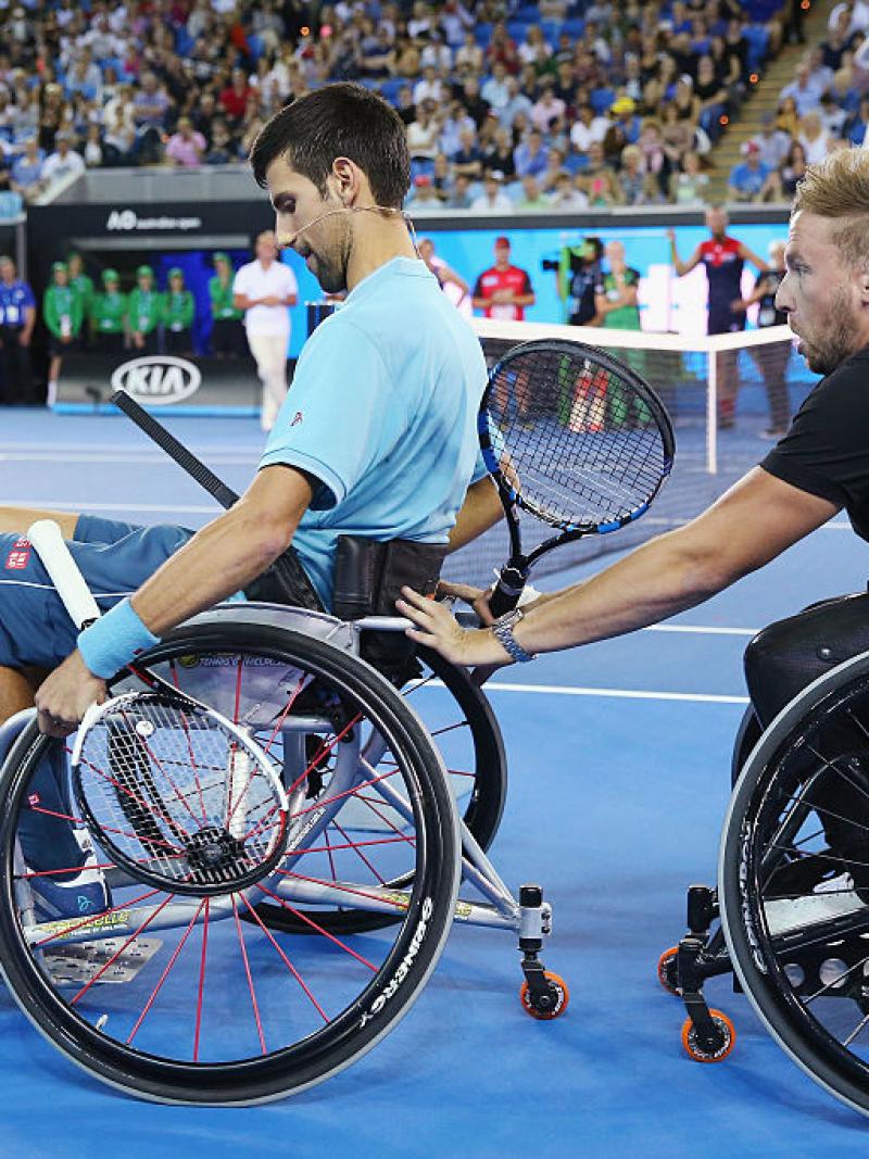 Two men in wheelchairs on a tennis court