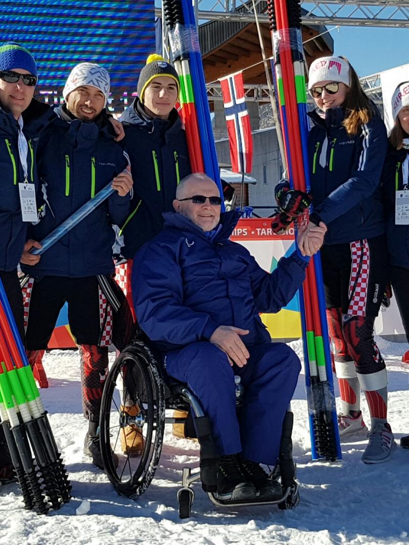 Group picture with skiers and man in wheelchair