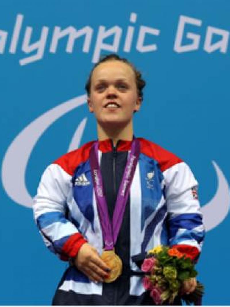 A picture of a woman with a gold medal around her neck