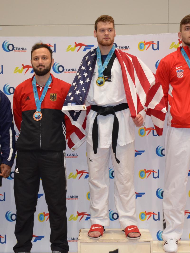 Taekwondo men standing on podium