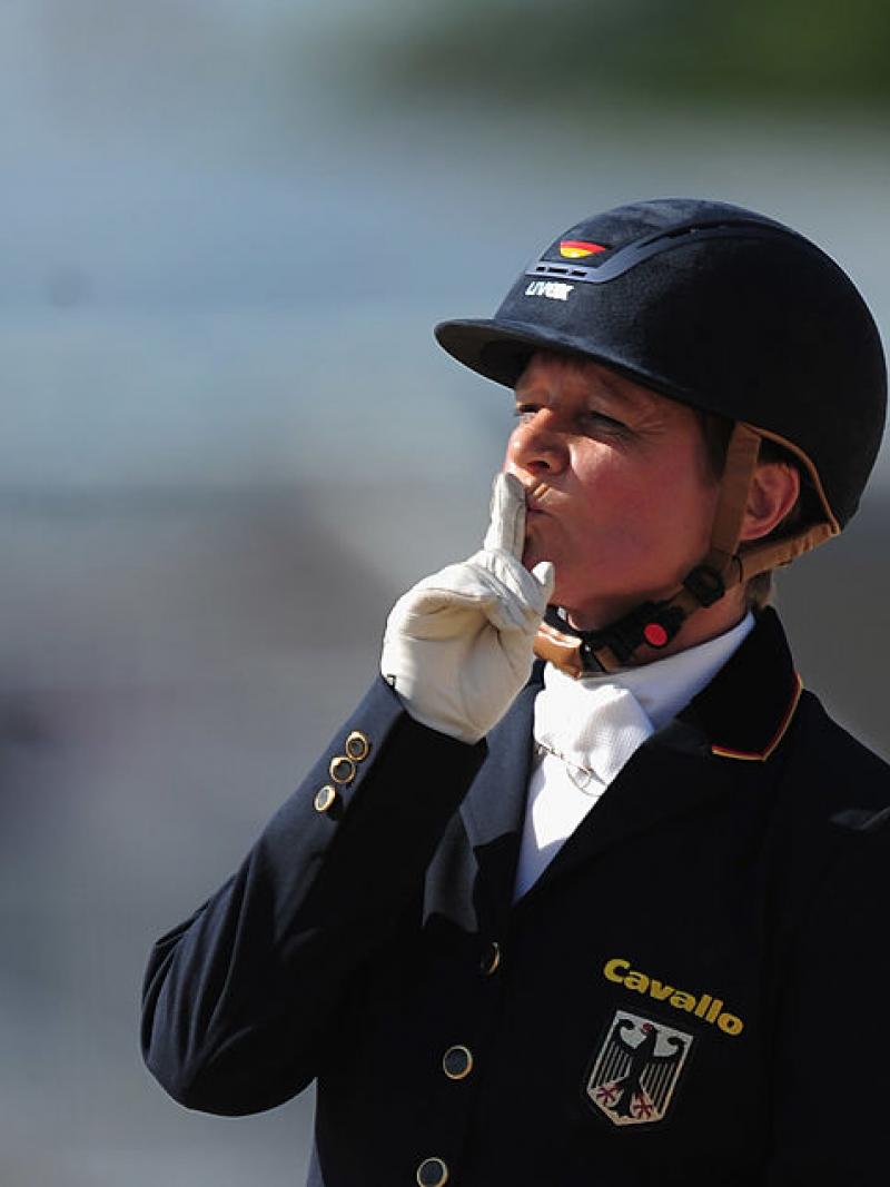 A female rider puts her finger to her lips