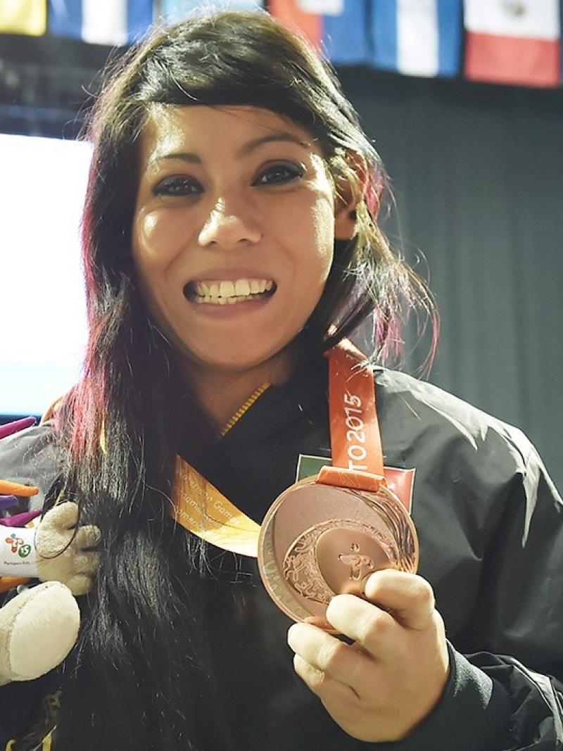 a Para athlete holds her medal and smiles