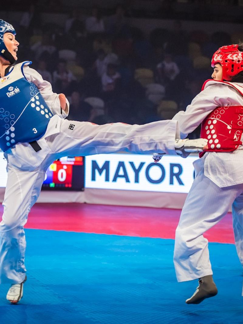 two female Para taekwondo fighters kick at each other