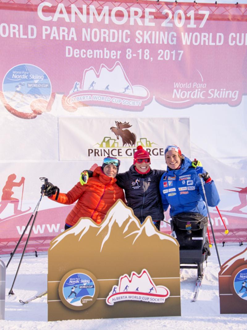 Podium shot of Andrea Eskau, Marta Zainullina and Birgit Skarstein embracing.