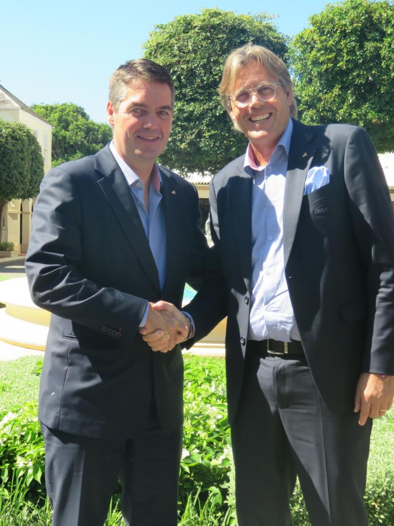 two men smiling and shaking hands