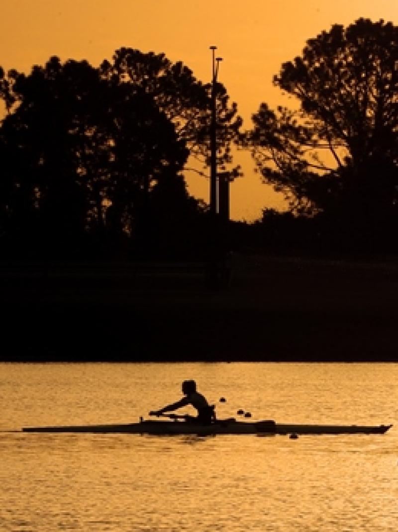 Sunset photo of rower in a boat on the water