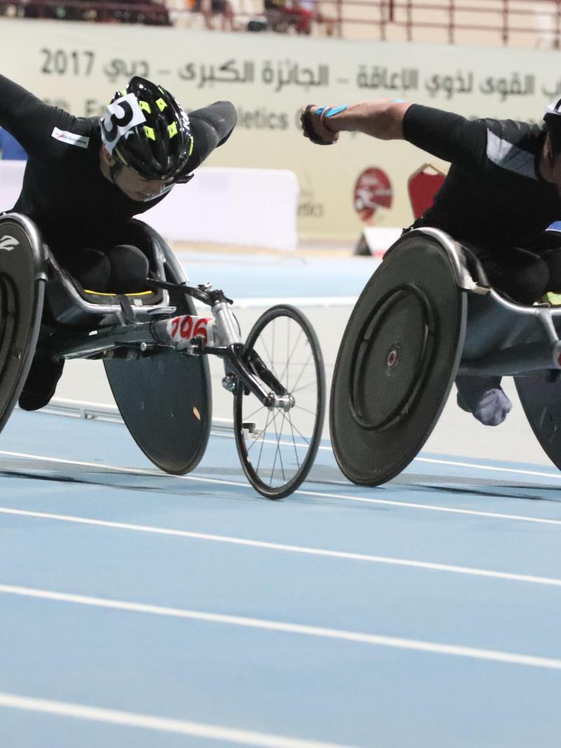 two male wheelchair racers come round the final bend