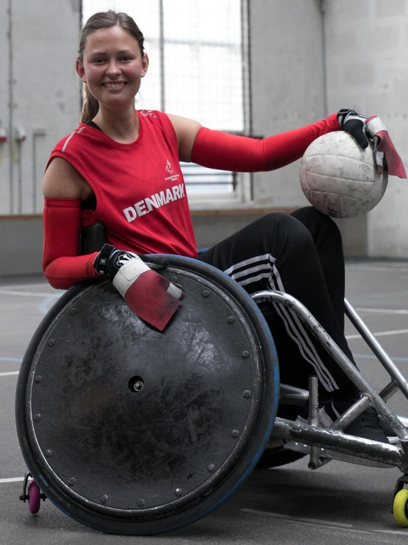 a female wheelchair rugby player poses with the ball