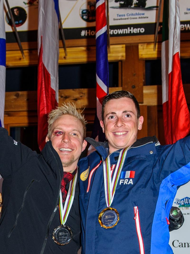 two male Para snowboarders on the podium with their medals