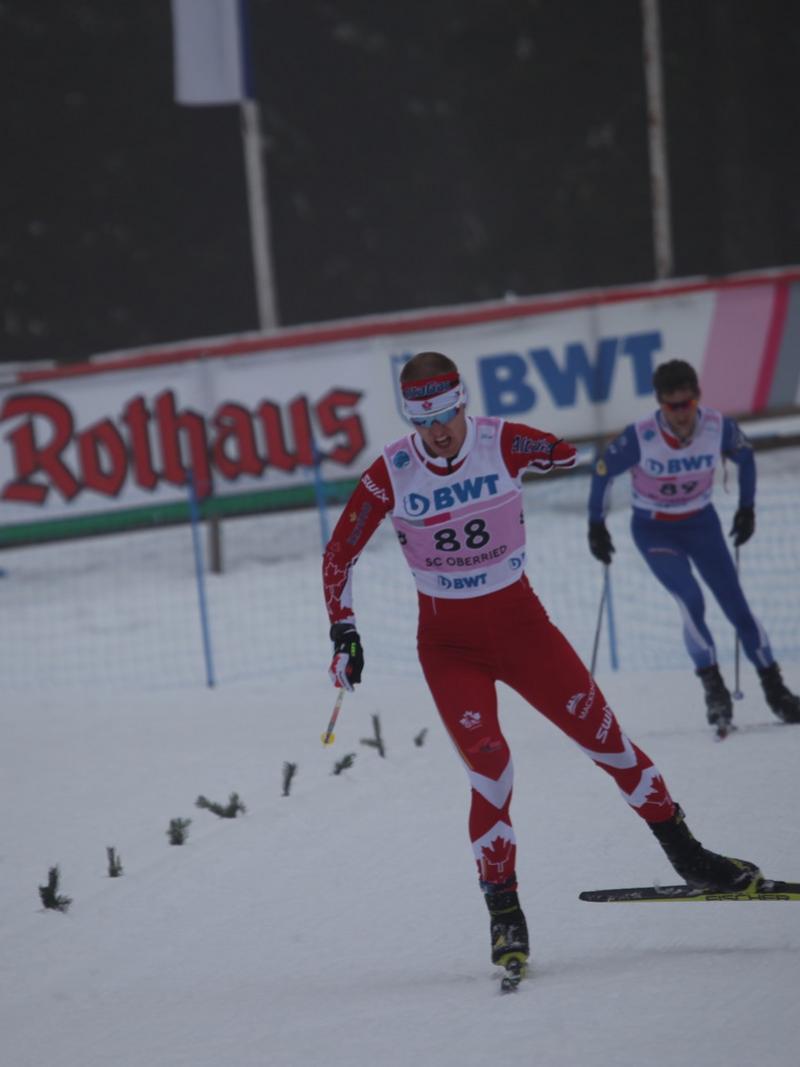 a male biathlete skies towards the finish line